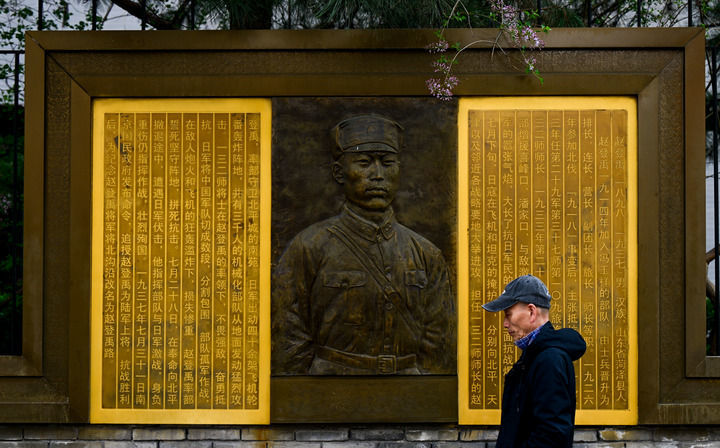 在北京市西城区赵登禹路，市民从赵登禹将军英雄事迹主题浮雕前走过（3月26日摄）。新华社记者 刘金海 摄