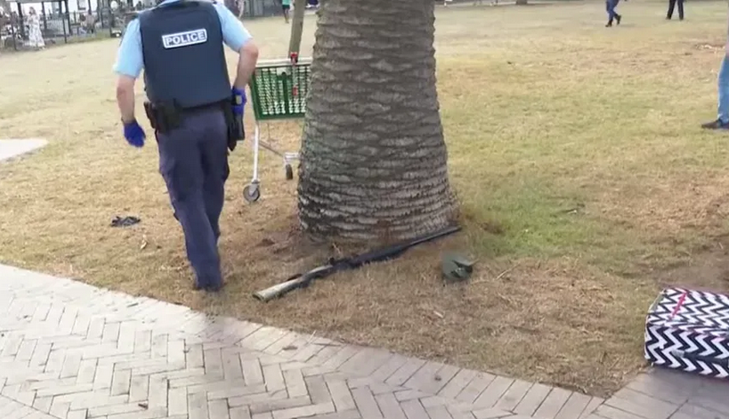 在警戒区域内,地面可见一顶棒球帽和疑似一支霰弹枪,警员在旁值守。(ABC)