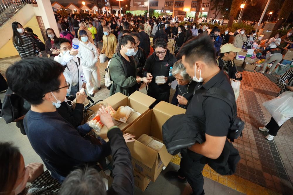 11月27日，义工在宏福苑附近向受火灾影响的市民派发物资。新华社发（吕小炜摄）