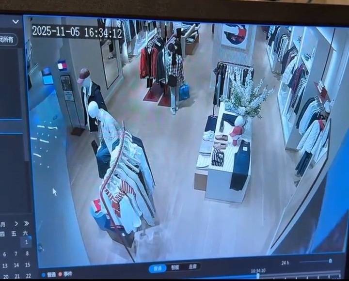 女子疑似正在对着衣物点火。监控视频截图