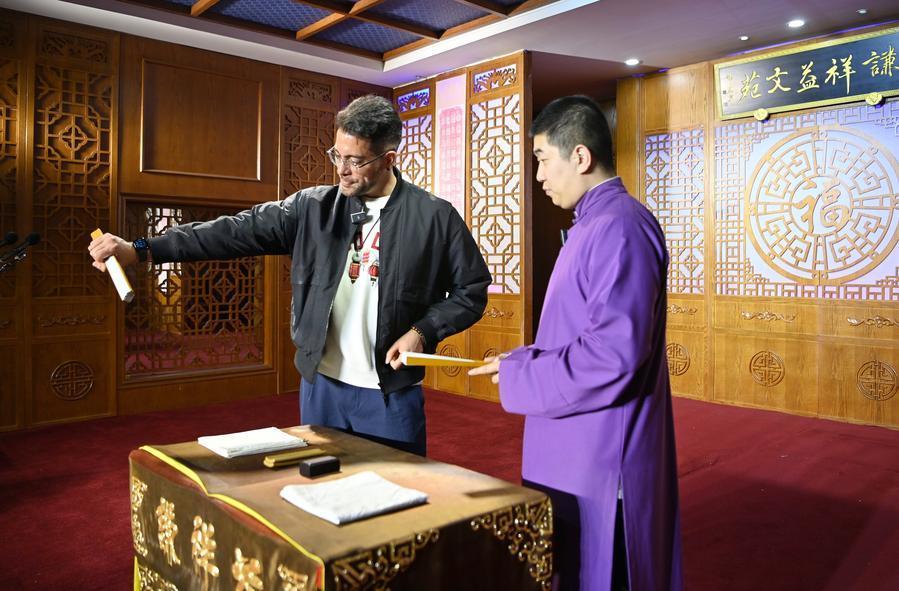 4月24日，在天津市红桥区谦祥益相声茶馆，吴瑞龙（左）和相声演员在台上交流。