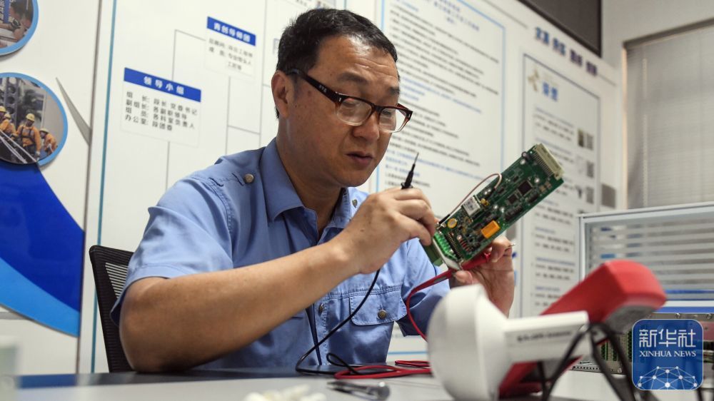 彭春林在工作室对接触网作业车防倾覆装置的元件进行测量(4月22日摄)。