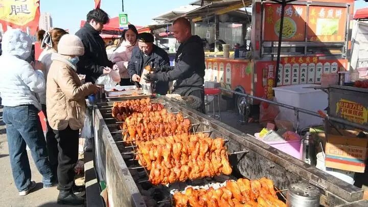 曹洼大集现场,游客在购买美食。新华社发