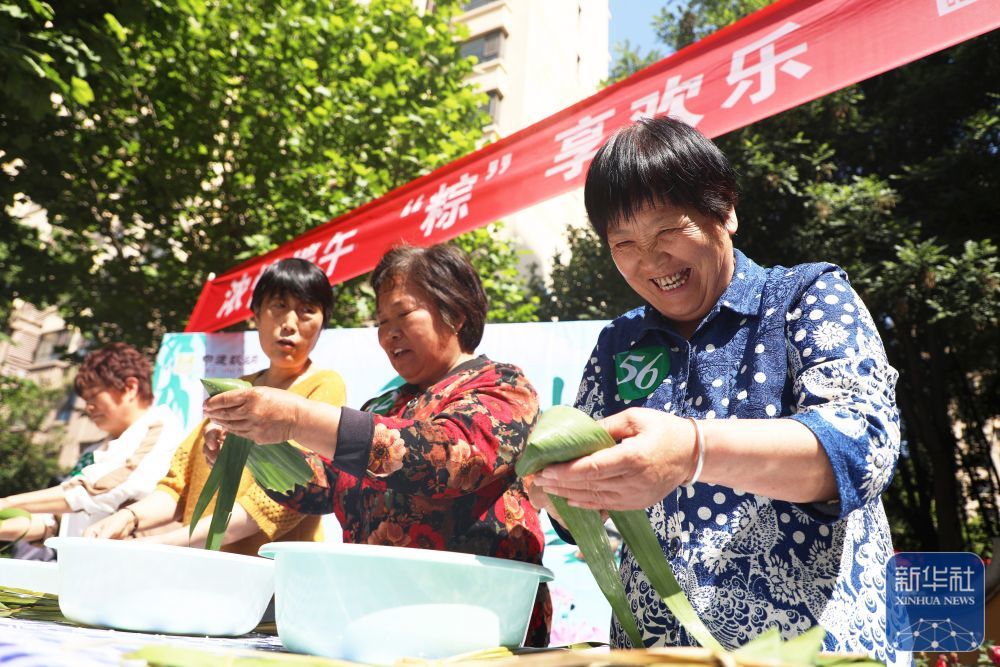 ↑ 5月24日，在河北省唐山市丰润区太平路街道中建城一社区，居民在参加包粽子比赛。新华社发（朱大勇摄）