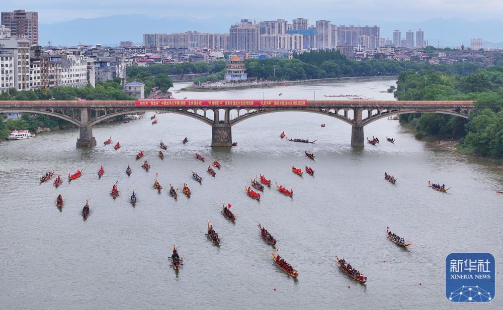 ↑ 5月22日，龙船在湖南省永州市道县县城潇水河面划行备战（无人机照片）。新华社发（何红福摄）