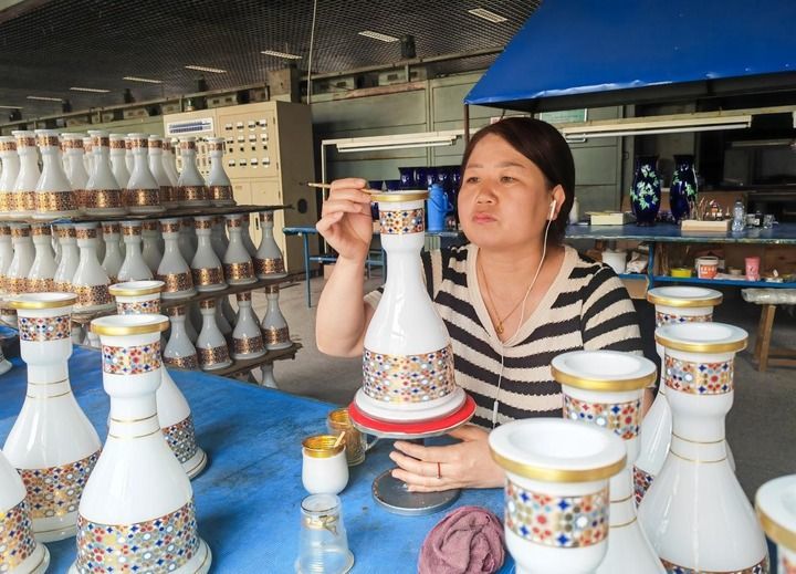 6月25日，在山西省祁县红海玻璃厂的生产车间里，工人闫润香正在给玻璃器皿描边。新华每日电讯记者 柴婷摄