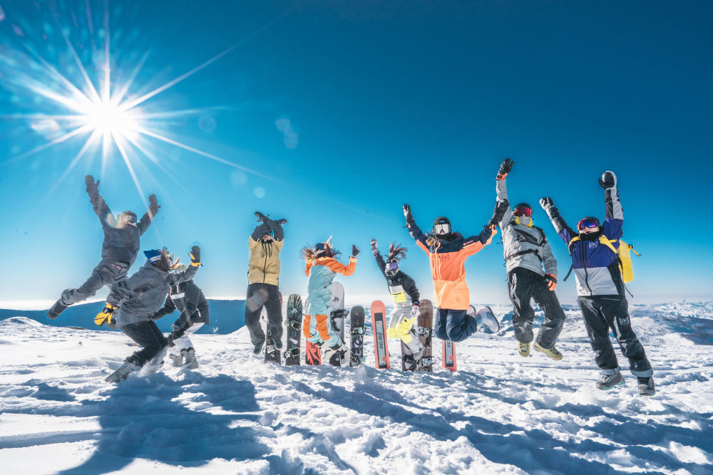 11月26日，可可托海国际滑雪度假区内，滑雪爱好者们从雪地上同步跃起，氛围欢快，庆祝新雪季的启幕。（新华社发 靳冰 摄）