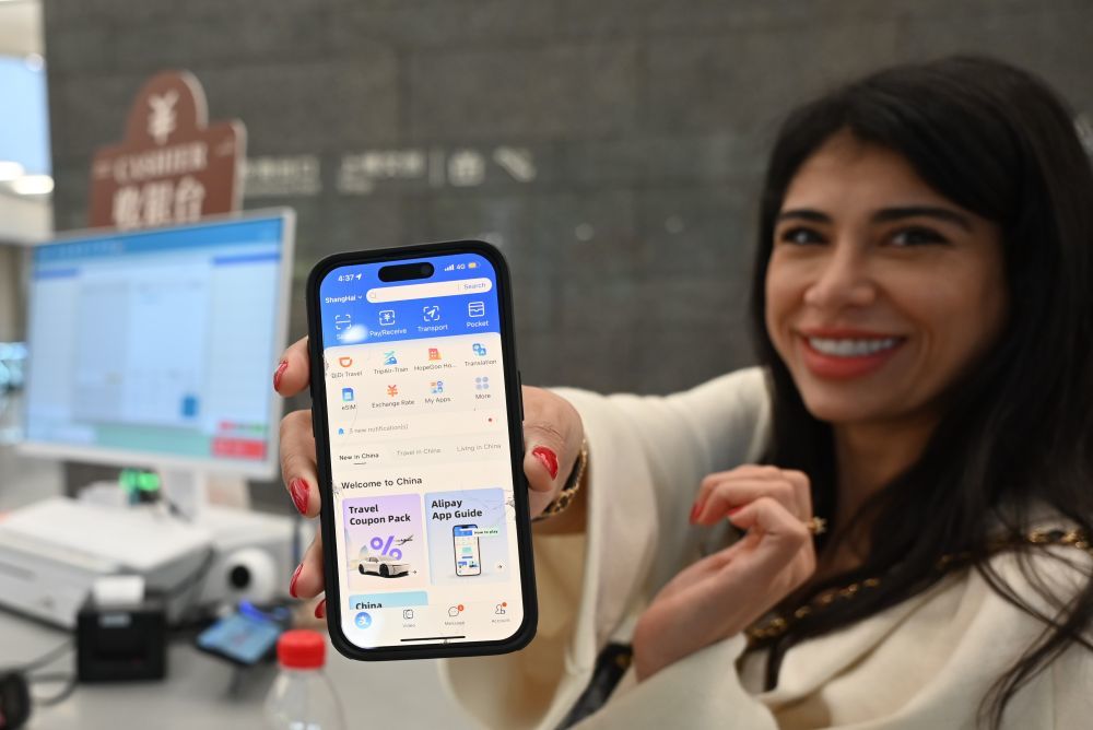 5月28日,在上海博物馆东馆文创商店,一名外国游客展示她的支付宝App。新华社记者 陈爱平 摄