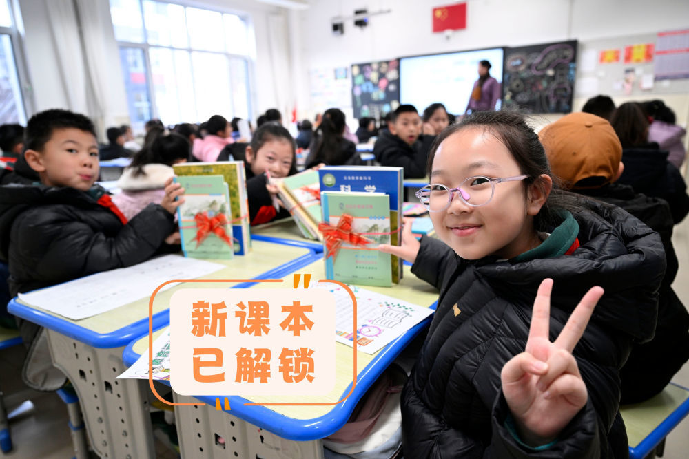 2月16日，宁夏银川市兴庆区实验二小学生在展示领到的新课本。新华社记者 王鹏 摄