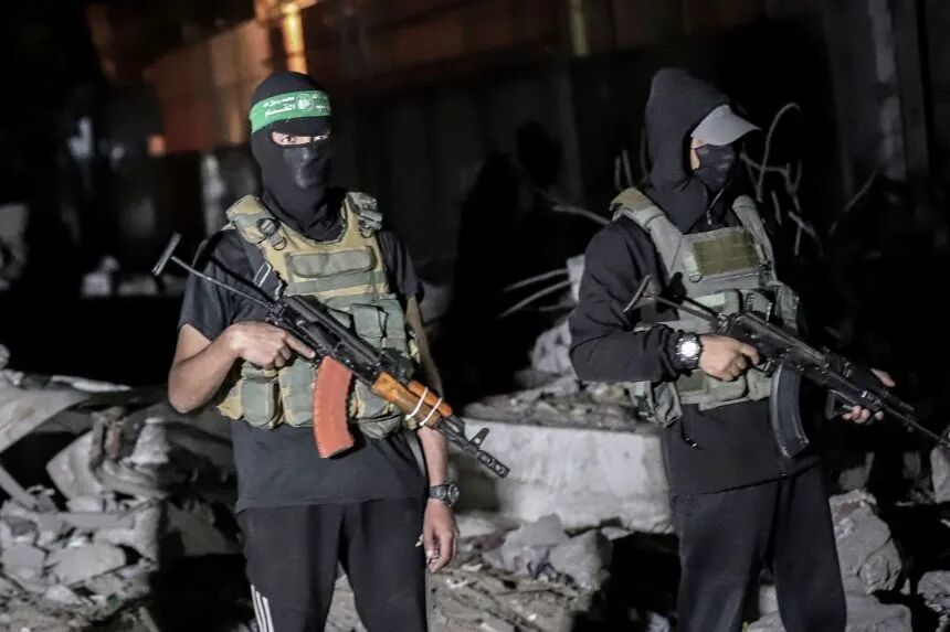 Palestinian militants wearing the uniform of the al-Qassam Brigades, the military wing of Hamas, monitor vehicles of the International Committee of the Red Cross as they collect the remains of Israeli hostages handed over by Hamas in Gaza City, Gaza, on Wednesday, October 15, 2025.