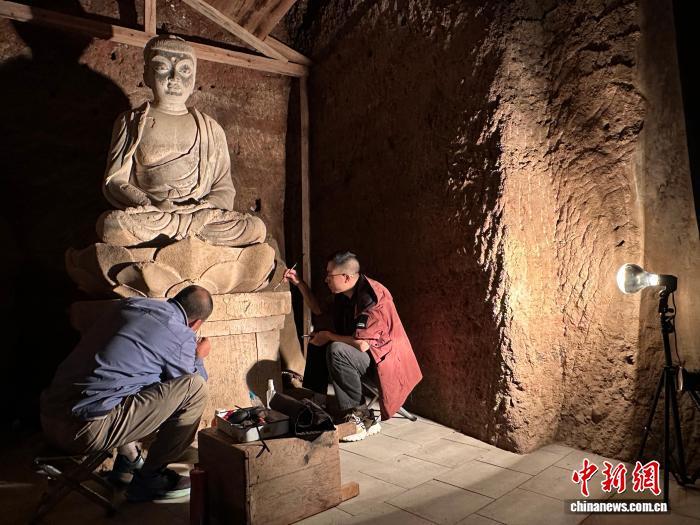 9月2日，麦积山石窟第133窟内，牟常有（左）和徒弟李浩亮（右）正在进行修复工作。中新社记者　丁思　摄