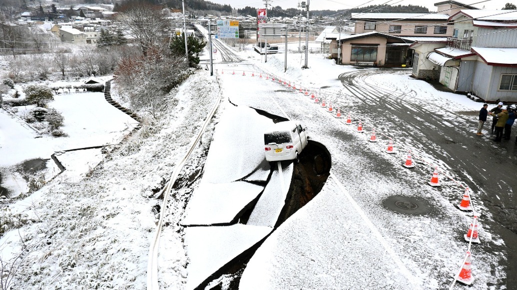 当地时间2025年12月9日,日本青森县东北町,一辆汽车停在因7.6级地震而受损的坍塌道路上。 视觉中国 图