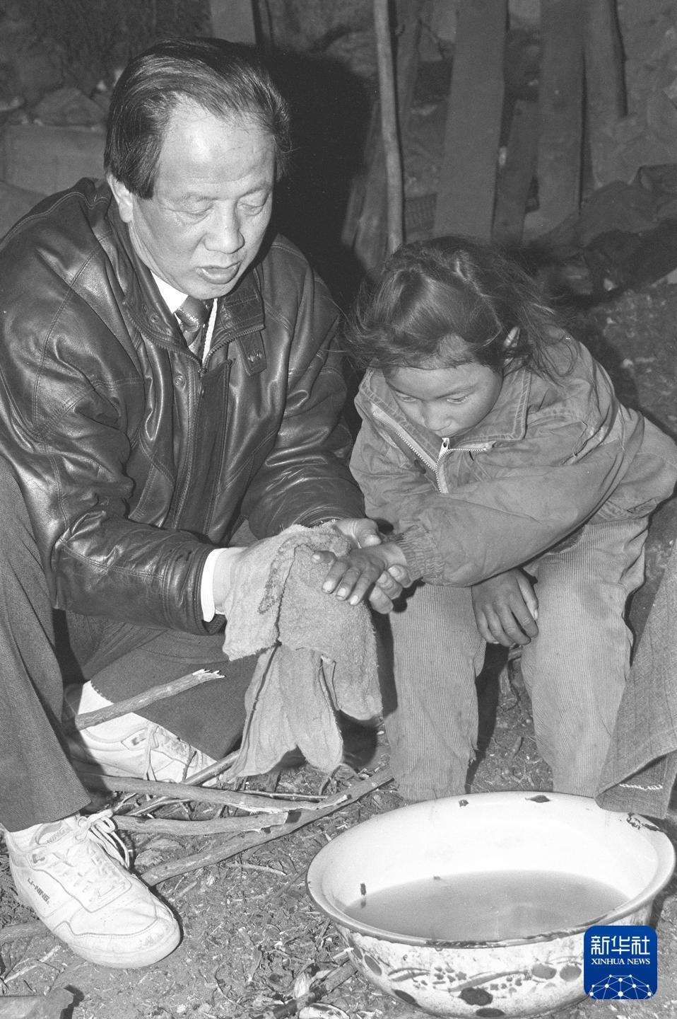 图为时任拉萨市副市长孔繁森在墨竹工卡县调研期间,专程看望7岁藏族孤儿措姆并为其洗手洗脸。