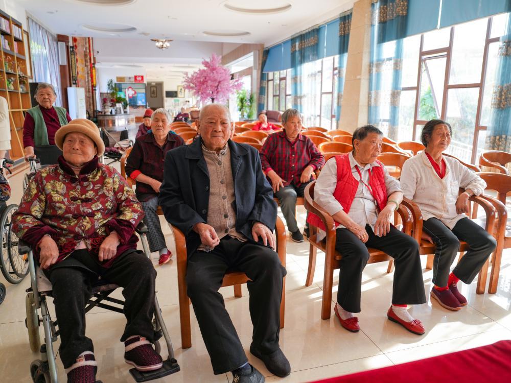 ↑在四川省南充市五福堂颐养院，刘寿山（前排左二）与老人们一起看电视（4月9日摄）。