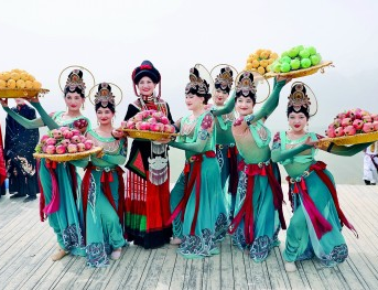 5月，新疆昆仑山景区，游客（左三）与舞台剧《神仙游昆仑》演员合影。本报记者孙金行摄/光明图片
