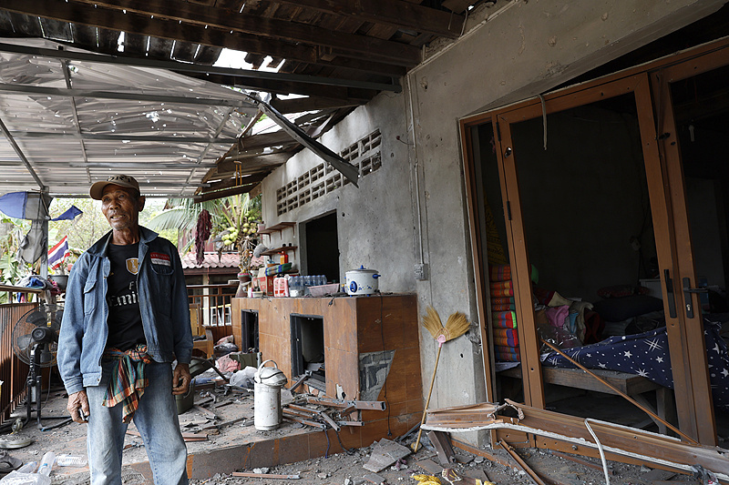 △当地时间12月10日,一名泰国村民查看自家在冲突中受损的房屋。