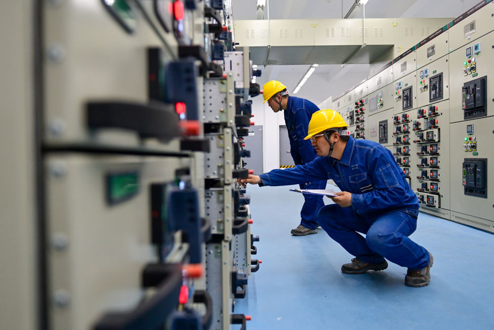 6月10日，在哈密—重庆&plusmn;800千伏特高压直流输电工程新疆送端站——巴里坤换流站，运检人员在配电室进行巡检工作。新华社记者 丁磊 摄