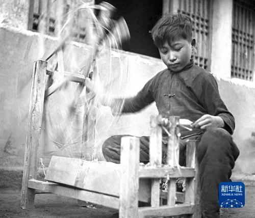 1943年,陕甘宁边区儿童在纺线。郑景康 摄