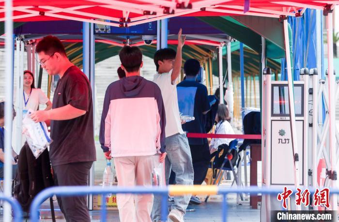 6月7日,湖北武汉,在武汉市第四中学考点,考生进入考场前挥手向家长致意。当日,2025年全国高考拉开帷幕。 中新社记者 张畅 摄