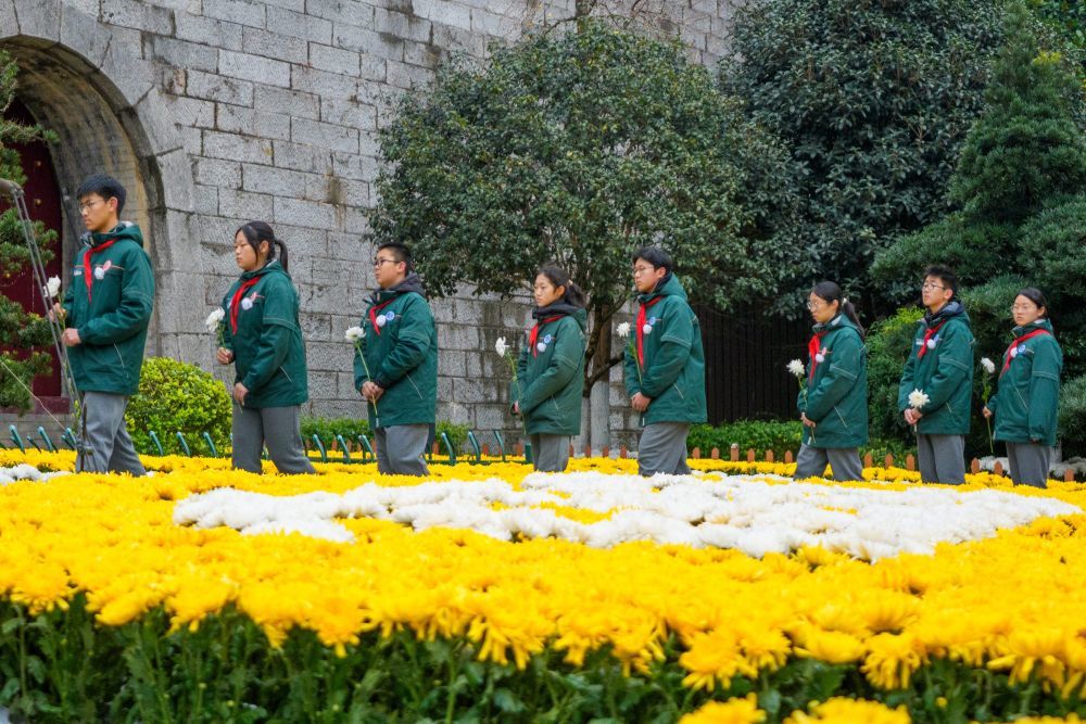 12月13日，学生在位于江苏南京的侵华日军南京大屠杀死难同胞丛葬地（正觉寺）参加悼念活动。新华社发（杜懿摄）