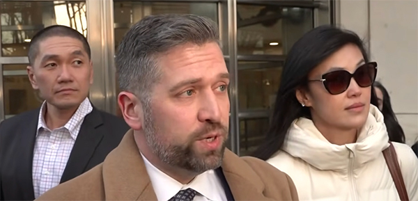 琳达·孙(右)和克里斯·胡(左)站在律师身后。 视频截图