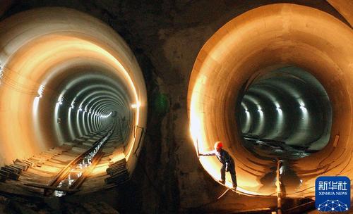 2003年12月10日，南京地铁一号线一期工程实现全线贯通，一名工人在隧道内调整照明灯光。新华社记者 徐澎 摄