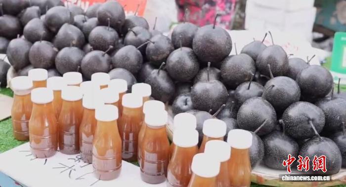 12月13日,沈阳小河沿早市,冻梨堆旁摆着鲜榨的冻梨汁。李雪飞 摄