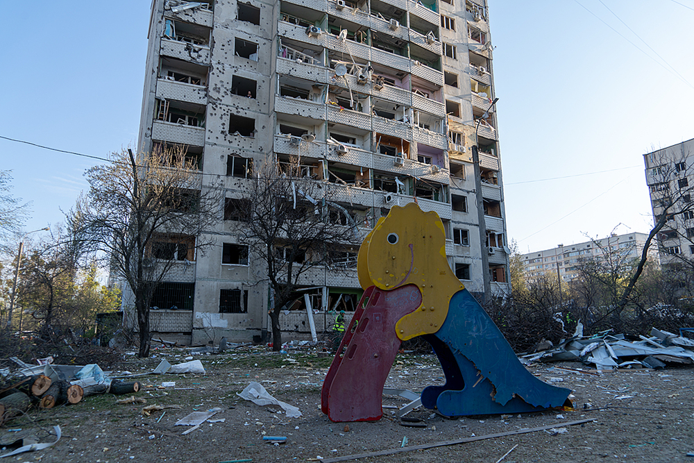 2025年4月18日,乌克兰哈尔科夫,俄罗斯导弹袭击后,一个受损住宅楼附近的游乐场上满是废墟和碎片。视觉中国 资料图