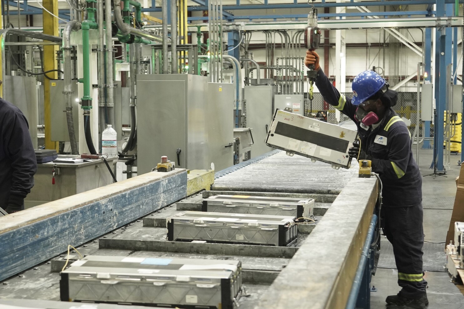 美国佐治亚州科文顿的一处电池回收工厂,一名工人正将废旧动力电池装载到破碎机上。