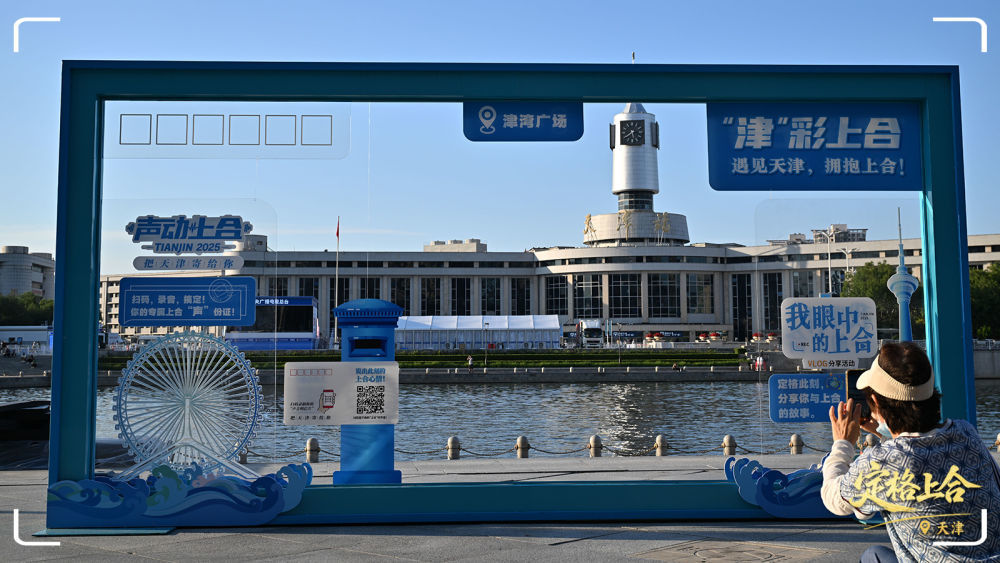 天津津湾广场，游客在一处“2025年上海合作组织峰会”主题装饰物打卡。