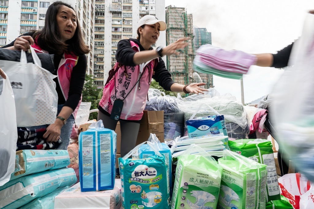 11月27日,香港大埔,宏福苑附近的广福邨公众平台上,社区关爱队和热心市民等在整理纸尿裤等捐赠物资。