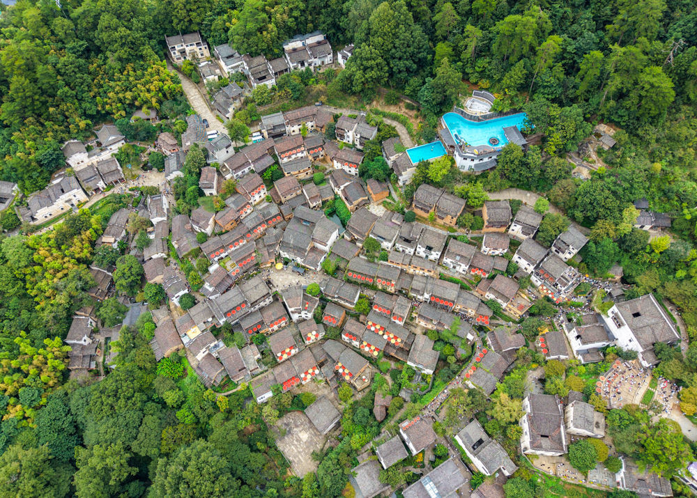 ↑2025年9月21日，江西省上饶市婺源县江湾镇篁岭村，徽派民居的木架上晾晒着红辣椒、玉米、南瓜、豆角等农作物。（无人机照片）CICPHOTO/胡敦煌 摄