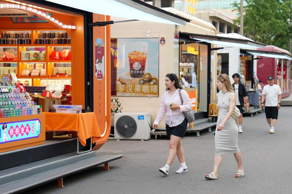 两名外国游客在北京市王府井大街参观游览。 新华社记者 鞠焕宗 摄
