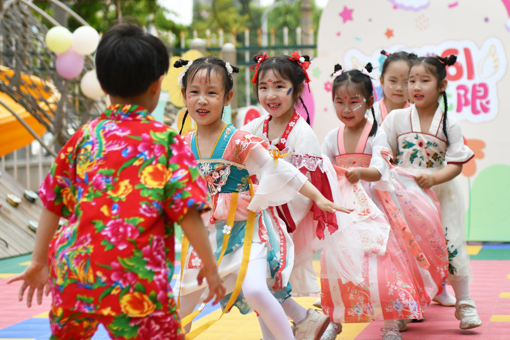 5月29日，山东省烟台市福山区城西幼儿园的小朋友在玩老鹰捉小鸡游戏。 新华社发（孙文潭摄）