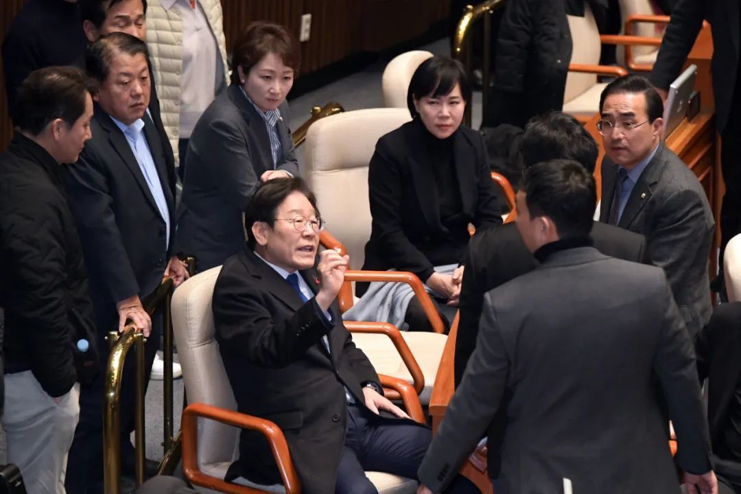 2024年12月4日，身处韩国国会内的李在明（中）。当日凌晨，韩国国会举行紧急全体会议，就“要求解除紧急戒严令”进行了投票。图/澎湃影像