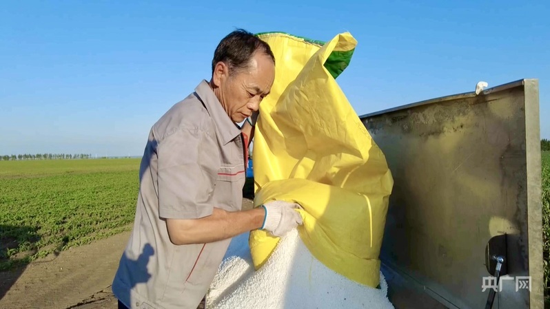 农户为玉米和大豆田精准施药、科学配肥（央广网发 郑明 摄）