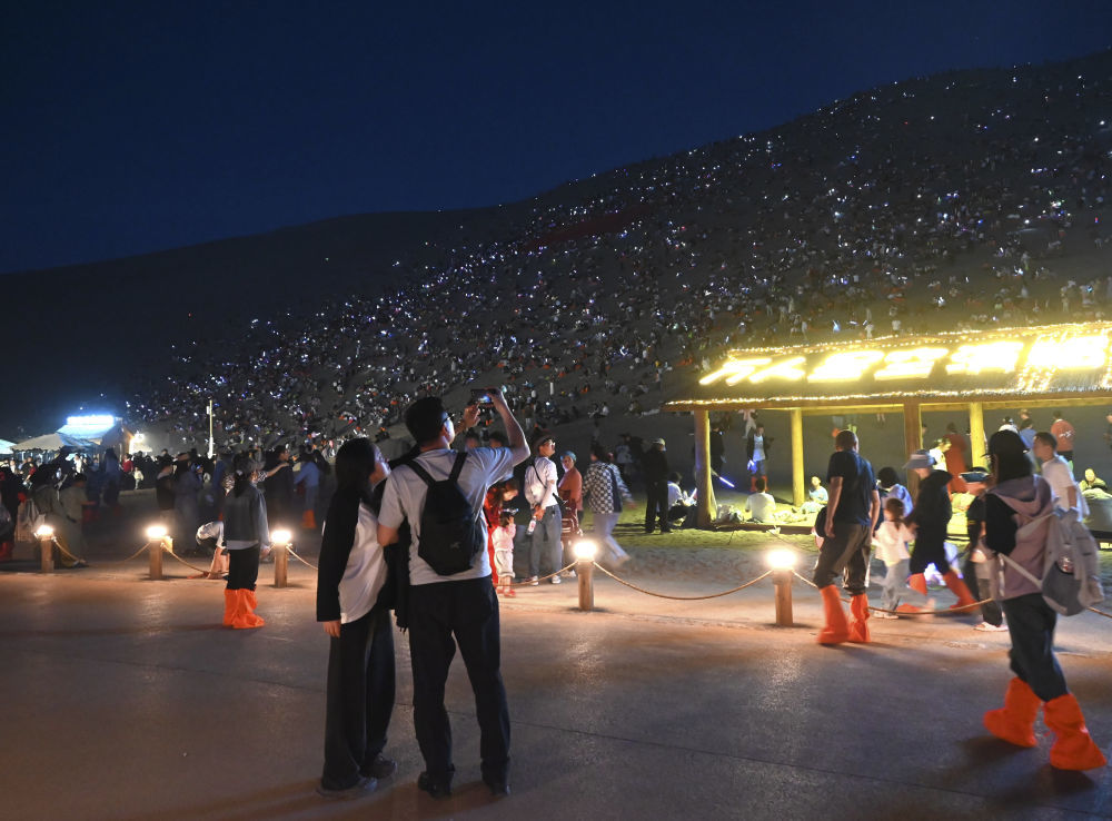 5月1日晚，游客在甘肃省敦煌市鸣沙山月牙泉景区参加万人星空演唱会。新华社发（张晓亮摄）