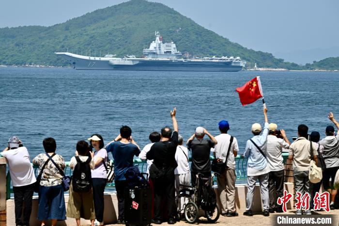7月7日，由中国人民解放军海军航空母舰山东舰，导弹驱逐舰延安舰、湛江舰及导弹护卫舰运城舰组成的航母编队完成在香港的访问活动，驶离香港。图为当天上午，香港民众手持国旗在海怡半岛海滨送别山东舰航母编队。　 中新社记者 李志华 摄