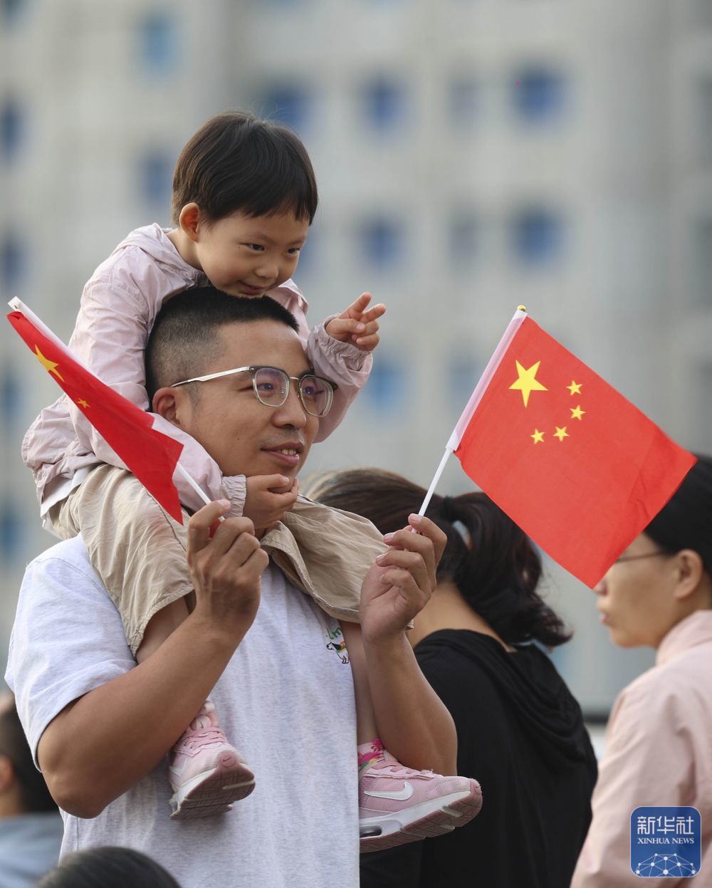 ↑ 10月1日,在河北省石家庄解放广场,小朋友在家长陪伴下参加升旗仪式。新华社发(梁子栋摄)