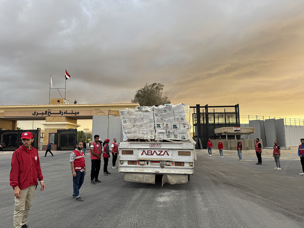 当地时间2025年10月12日,载有人道主义援助物资的卡车在埃及红新月会工作人员的监督下从拉法口岸埃及一侧驶向加沙。