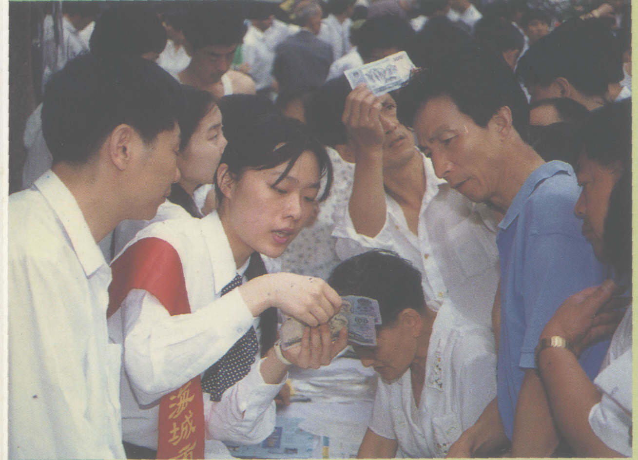 图为上海城市合作银行教市民识别假币