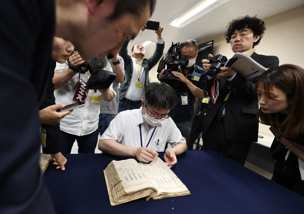5月14日，在日本东京，工作人员在日本国立公文书馆翻阅侵华日军细菌战部队“登字1644部队”留守名簿，寻找写有竹上胜利父亲宫下利市的文字记录。新华社记者贾浩成摄