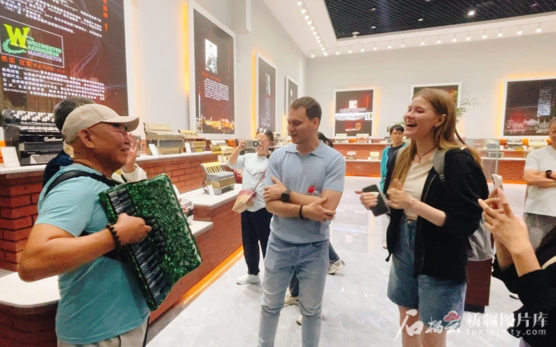 8月2日，在塔城市手风琴文化展示厅，民间手风琴艺人谷英福（左一）为北京大学留学生伴奏，演唱《喀秋莎》。石榴云/新疆日报记者 赵西娅摄