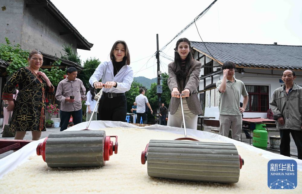 5月28日，在重庆市巴南区丰盛古镇，就读于重庆大学的俄罗斯留学生奥莉（左三）与哈萨克斯坦留学生玛丽（右三）一同体验糍粑的制作过程。