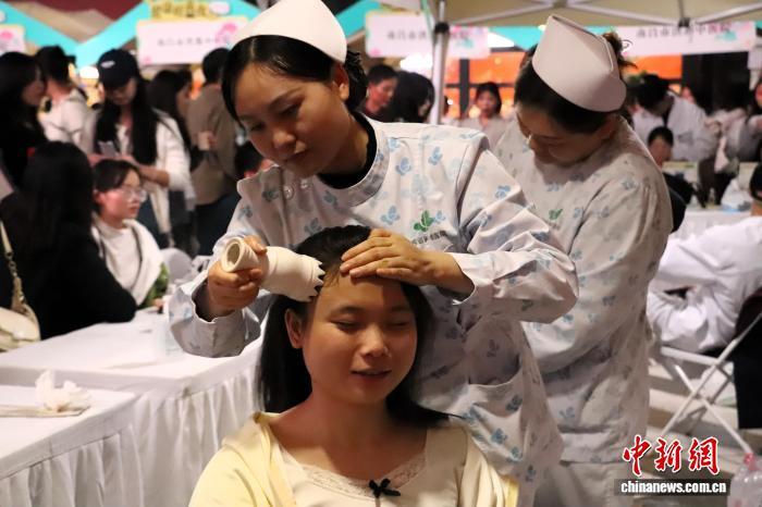 正在体验“艾灸头疗”的市民。 熊锦阳 摄