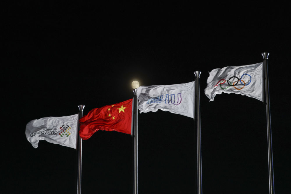 ↑这是开幕式上拍摄的成都世运会组委会会旗、中华人民共和国国旗、国际世界运动会协会会旗、国际奥林匹克委员会会旗（从左至右）。新华社记者 陈诚 摄