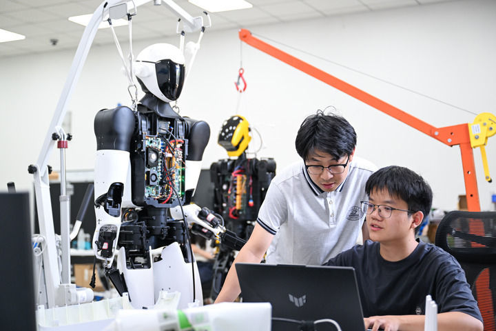 2025年5月29日,在位于湖北省武汉市的华中科技大学机械科学与工程学院,研究人员对“荆楚”人形机器人进行代码调试。新华社记者 杜子璇 摄