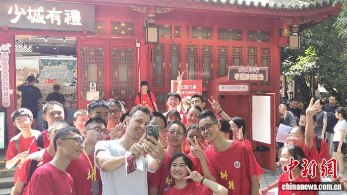 外籍游客在人民公园与提供文旅讲解服务的中学生志愿者影留念。 程青轩 供图