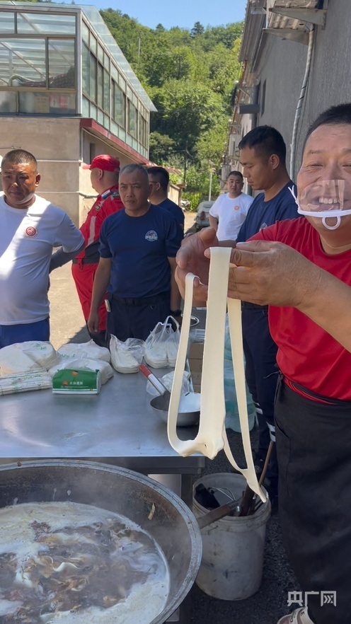 赵占胜(右)一边扯面一边和村民聊天(央广网发 受访者供图)