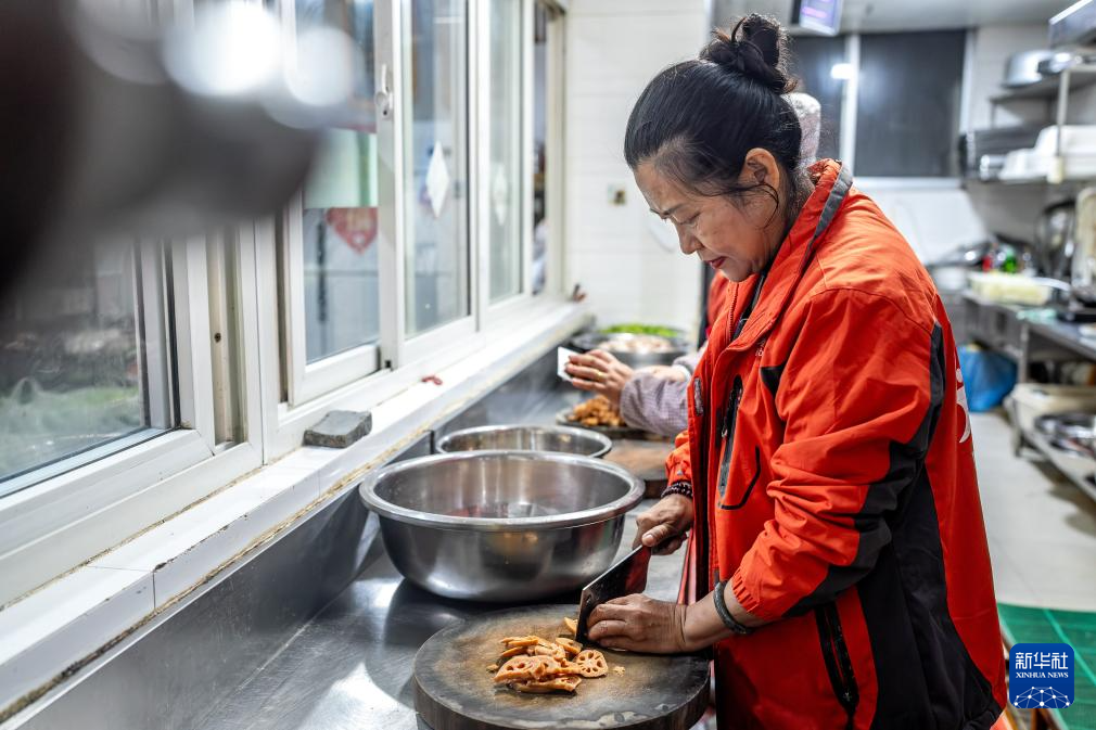 王兰兰在昆明市幸福家园小区爱心食堂切菜(5月28日摄)。